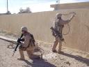 A soldier starts to paint, another one guards his back